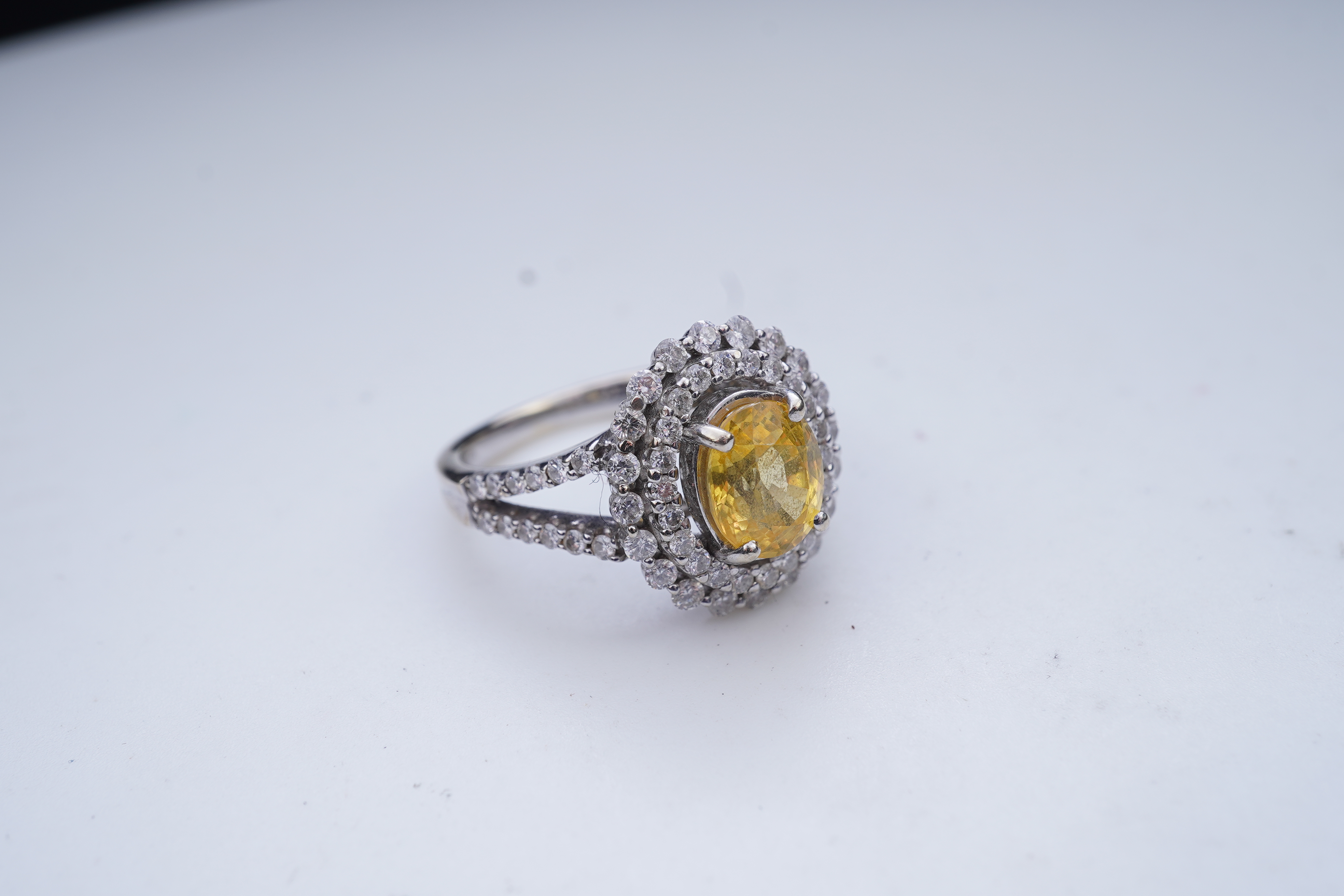 A yellow sapphire and diamond ring